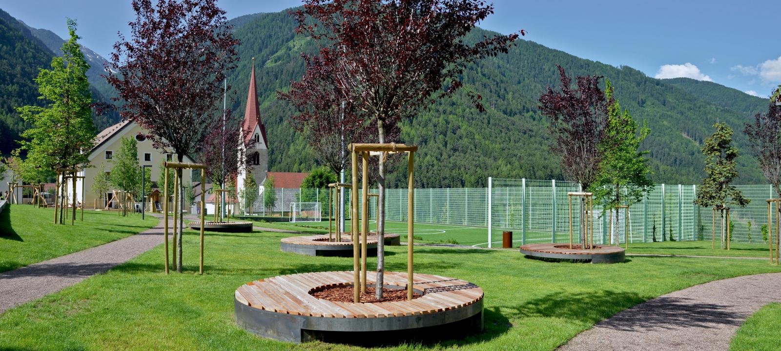 Giardino pubblico con alberi e posti da sedere 