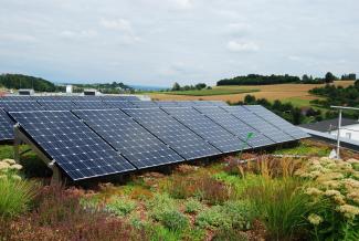 Man installs solar base frames on a green roof