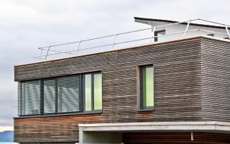 The inclined Fallnet® Safety Railing ASG lends the roof edge a pleasing look. Building with a railing on the rooftop
