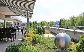 People on a roof garden with water feature and sitting area