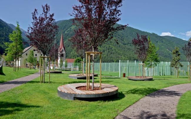 Giardino pubblico con alberi e posti da sedere 